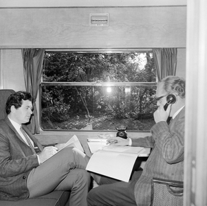 152329 Afbeelding van twee heren in het compartiment met telefoon in het directierijtuig NS 20 ( Kameel ) van de N.S.